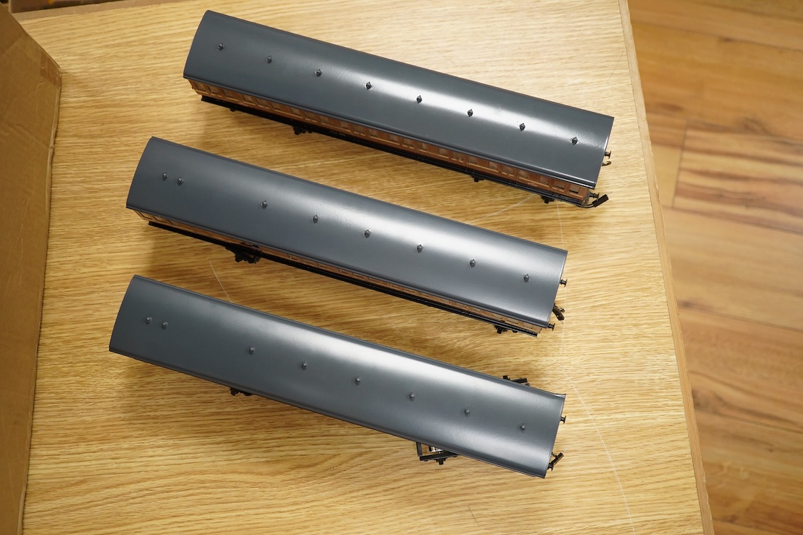 A boxed 0 gauge Darstaed tinplate Metropolitan Railway set of bogie coaches, a rake of five coaches in teak livery including; two Brake Thirds, two Full Thirds, and a Full First, fitted with internal lighting throughout